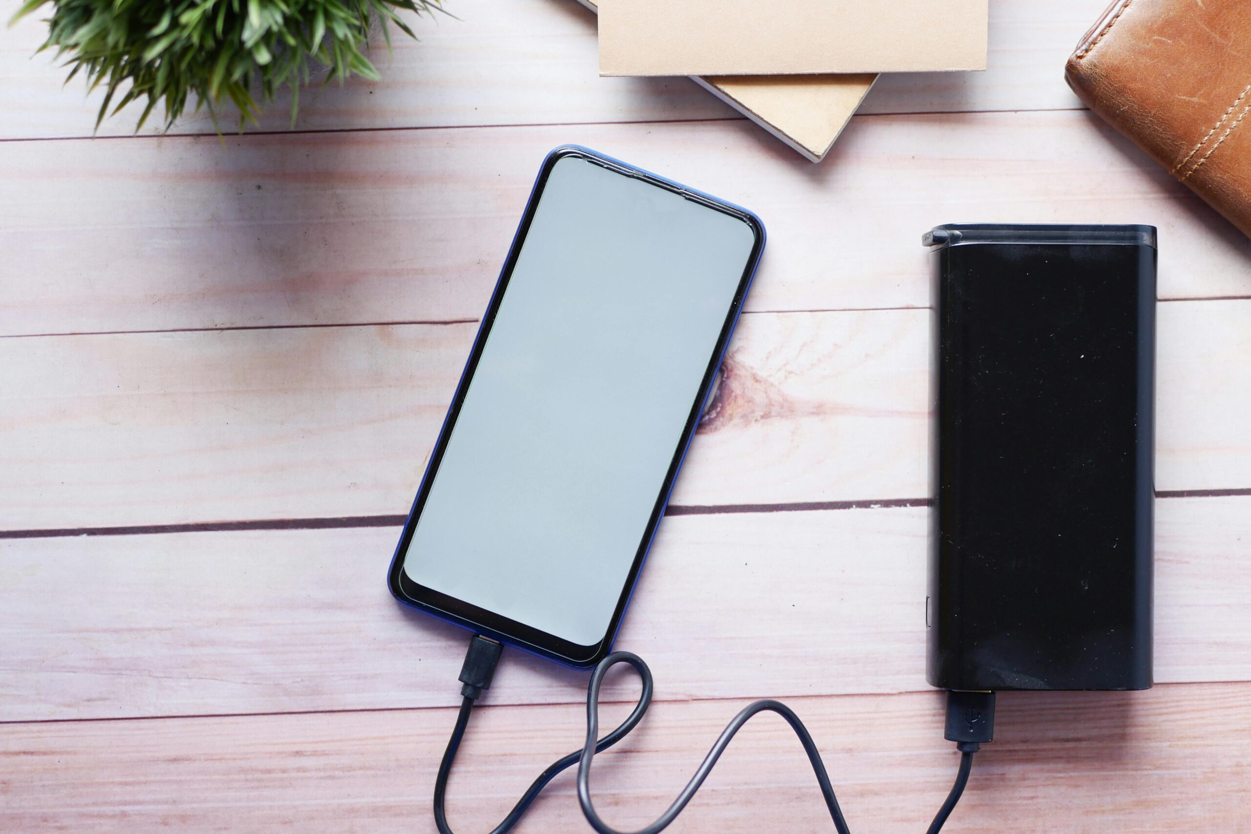 モバイルバッテリーでスマートフォンを充電しているフリー写真