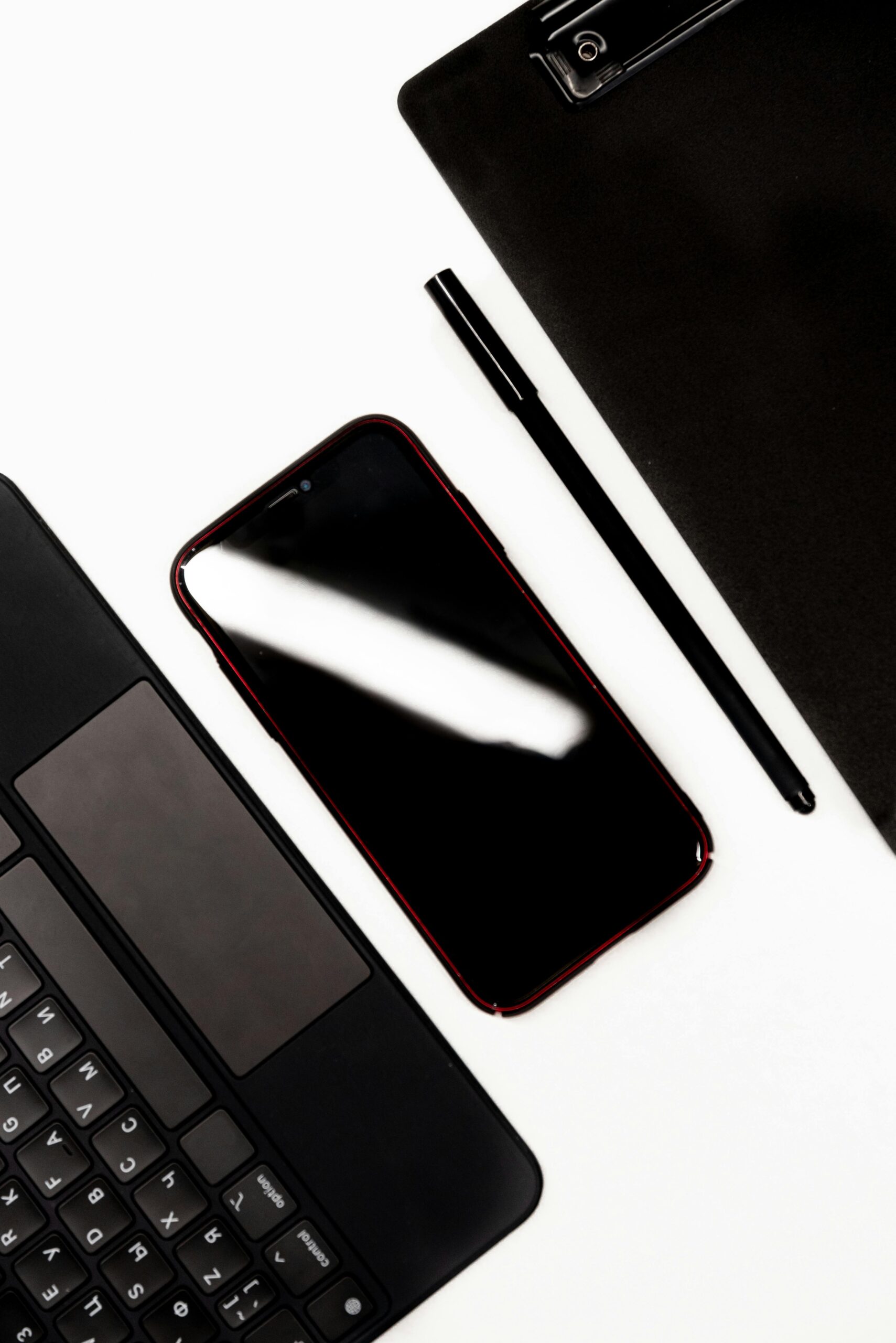 ノートPCとスマートフォンを並べて比較検討している様子のフリー写真