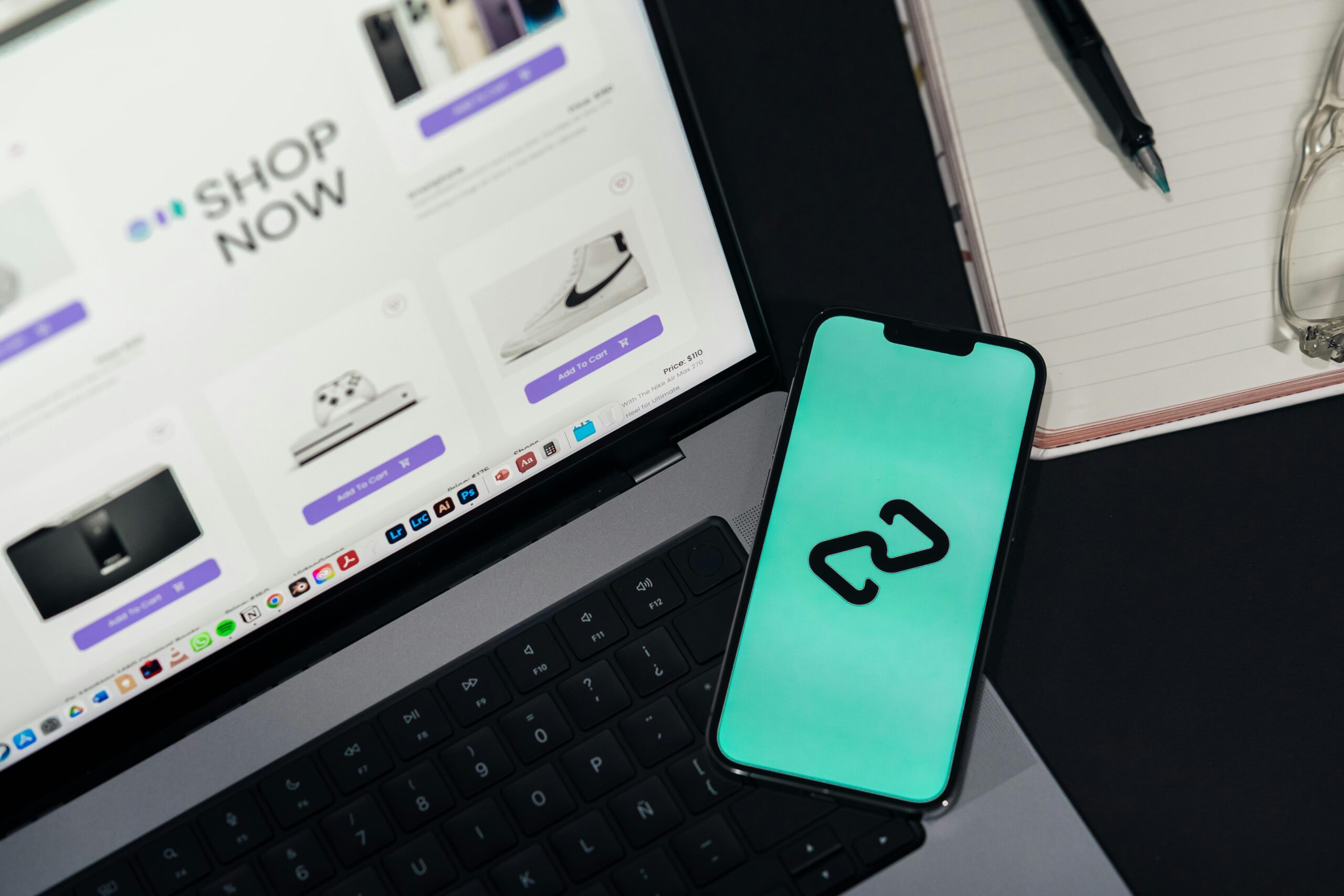 ノートPCとスマートフォンで価格を比較している様子のフリー写真