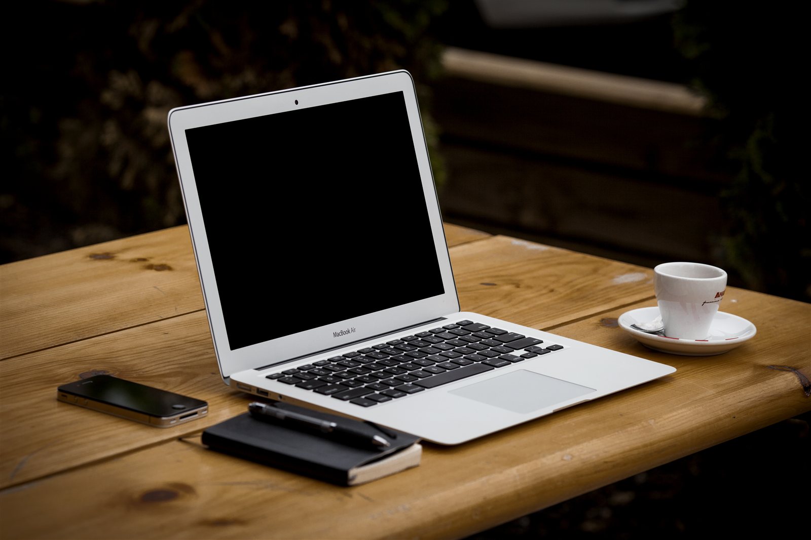 ノートとコーヒーが置かれたMacBook Air中心のデスク風景