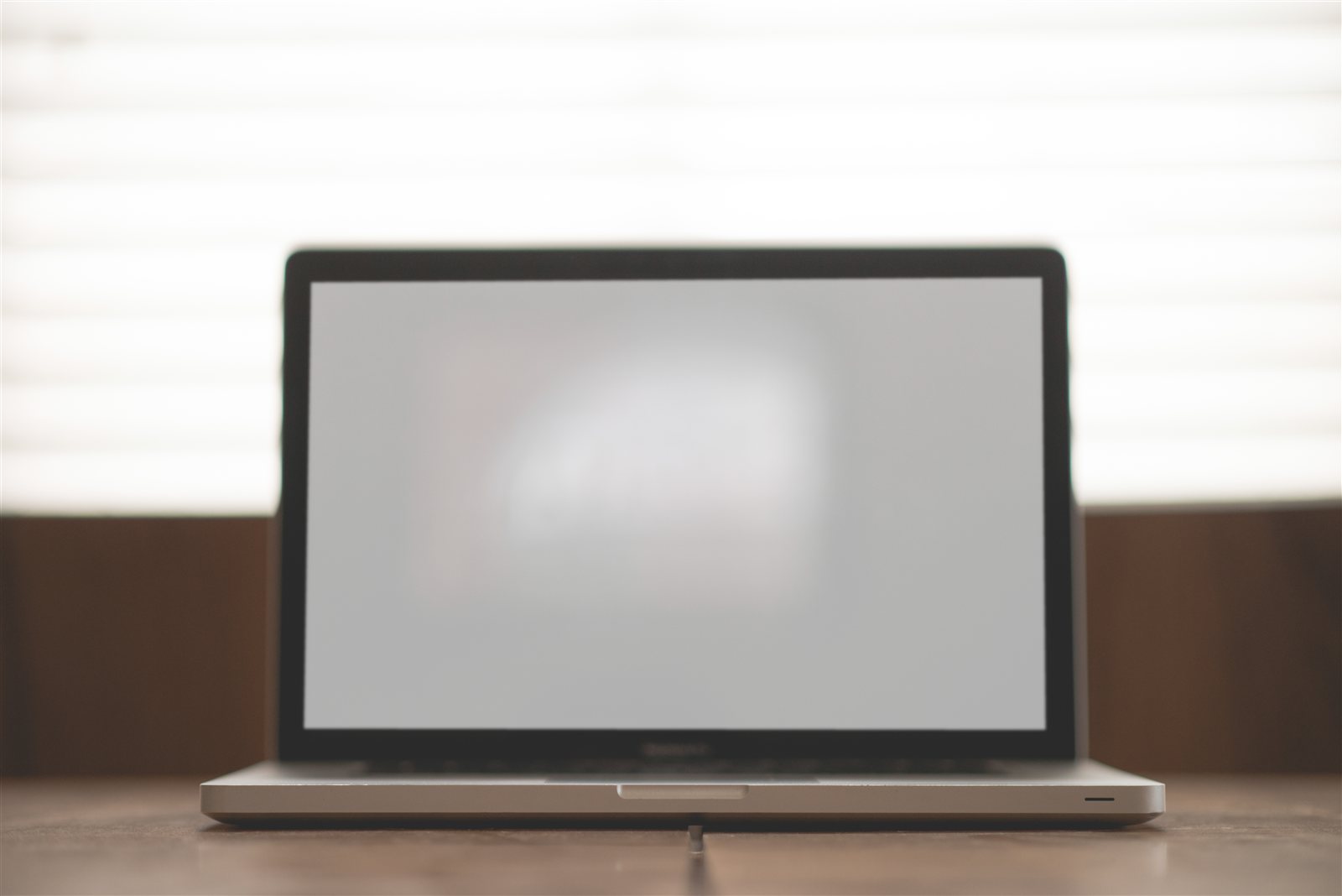 木製デスクに置かれたMacBook中心のミニマルな作業空間